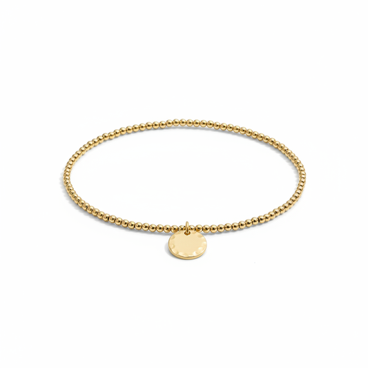 Gold beaded bracelet with small charm